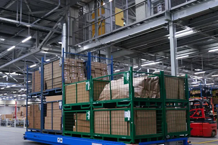 Wire mesh turnover racks loaded with cartons on a warehouse floor