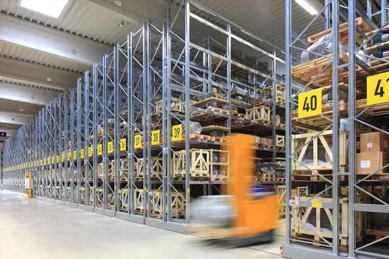Warehouse pallet racking loaded with crates, a forklift in the aisle